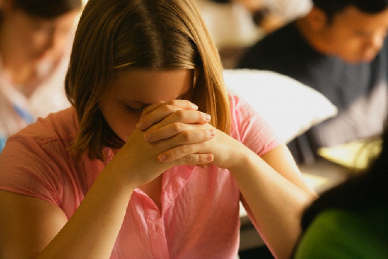 Teen Praying in Class